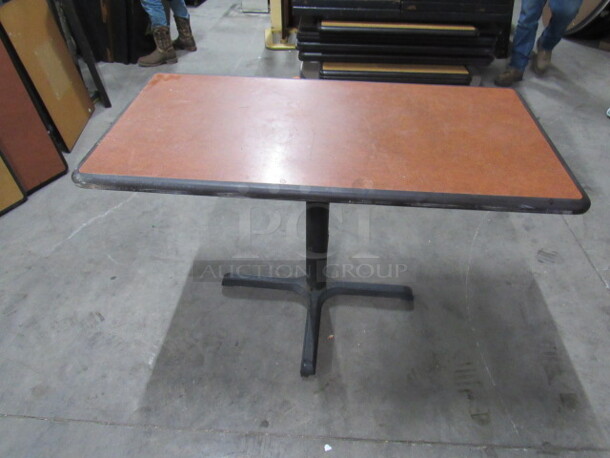 One Brown Laminate Table Top On A Pedestal Base. 47X24X30
