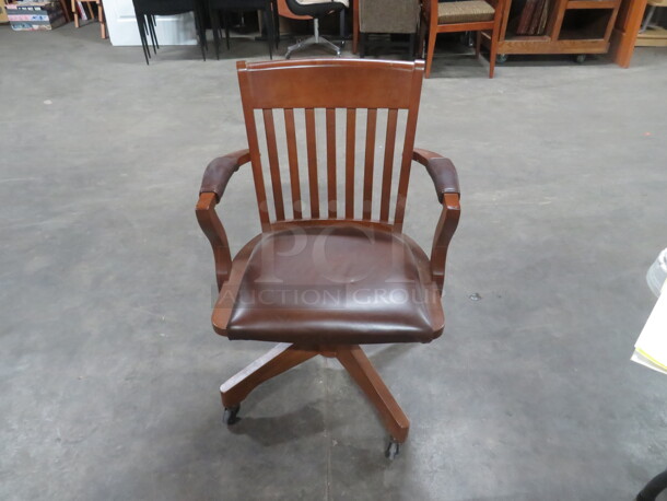 One Wooden Office Chair With Brown Cushioned Seat On Casters. 
