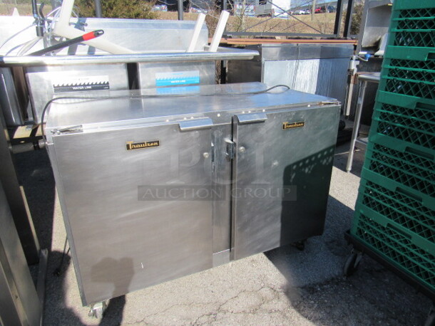 One SS Traulsen 2 Door Worktop Refrigerator With 4 Racks On Casters. Model# T20595H12. 115 Volt. 48X30X34