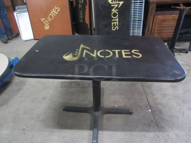One Black Table Top With The NOTES Logo On A Pedestal Base. 42X24X30