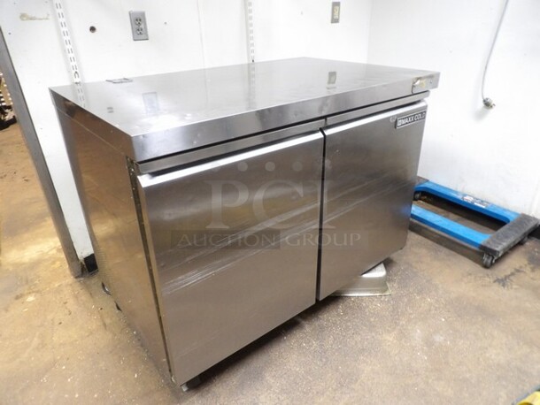 Maxx Cold, 2-Door Freezer Stainless Prep Table W/Moderate Wear. TESTED AND WORKING. 

Small Sections of Plastic on Inside of Doors Cracked/Missing and Dents/Scuffs to Inner Compartment. Missing One Castor and One Other Needs Reattached or Repaired. 

48.5