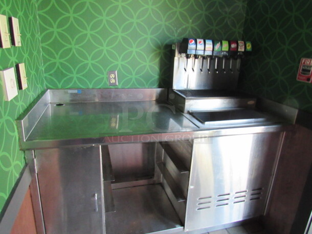 BUYER MUST REMOVE! One Stainless Steel Drink Table With 1 SS Door, Under Storage And An 8 Flavor Cornelius Soda Dispenser With Ice Well. 62X28X40