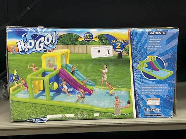 H2O GO Inflatable Water Park With Water Slide – Over 23ft Long. Contains: 01 SLIDE; 01 BLOWER (STAKES INCLUDED); 01 REPAIR KIT (MULTIPLE ASSORTED PATCHES); 1 STORAGE BAG; 10 BOUNCER STAKES; 1 PUC BALL SPRINKLER; 06 SMALL FLAGS; 01 WATER SPRAYING HOSE. Overall: 23ft – 4in x 10ft – 2in x 8ft – 8in.  - Image 1 of 9