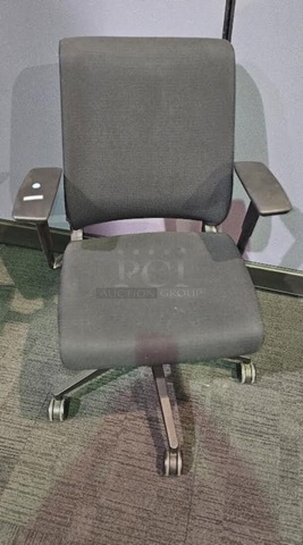 Black Steelcase office desk chair with armrests, black framing and wheels. Adjustable and in good condition! Shows normal signs of use. Measures 41” H x 26.5” W.  - Image 1 of 3