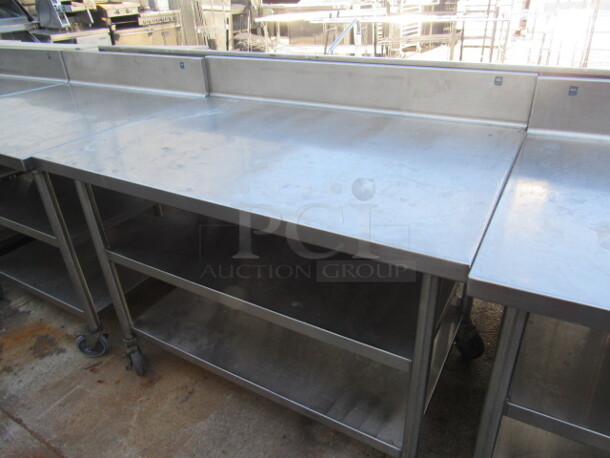 One Stainless Steel Table With 2 Stainless Steel Under Shelves, And Backsplash, On Casters. 48X33X40