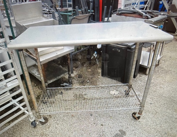 One Stainless Steel Table With A Metro Under Shelf On Casters. 48X21X12