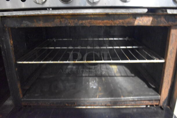 Imperial Commercial Stainless Steel Natural Gas Range With 10  Burners and 2 Ovens With Metal Racks On Commercial Casters.  - Image 5 of 7