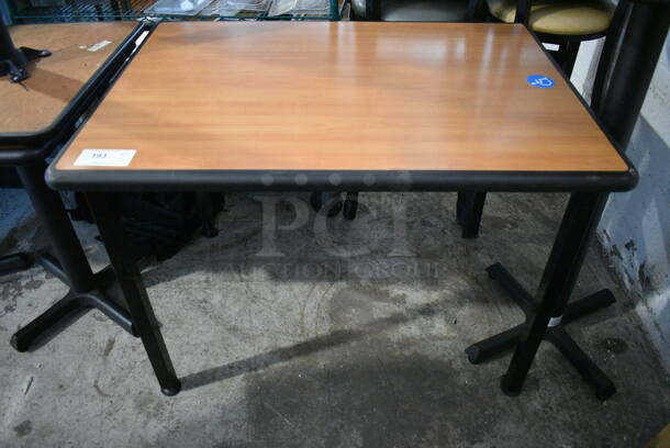 Rectangular Table With Faux Wood Top Trimmed in Black With Black Legs.