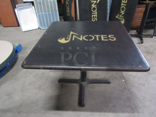 One Black Table Top With The NOTES Logo On A Pedestal Base. 36X36X30
