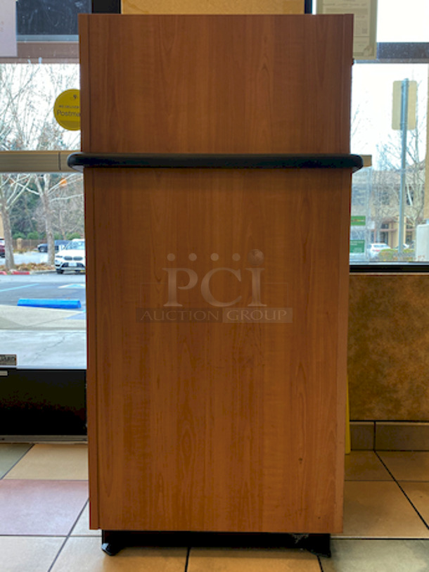 BEAUTIFUL! Plymold Round Drop Top Waste Receptacle with Tray Shelf, With 35 Gallon Liner. 
26x26x48

High pressure commercial laminate top and cabinet
Molded polyurethane edge designed for high traffic areas
8" Drop hole with Dur-A-Edge finish
Provides hygienic seal between laminate and receptacle edge
1.5" Radius corners on top
Rolled edge profile
1-1/8" thick 45 lb density particleboard core
Underside has phenolic backer to protect from moisture
Includes 35 gallon liner with casters
Tray shelf is 21.5"W x 11.25"D
Satin Nickel hinge and door pull
Leveling glides included - Image 4 of 4