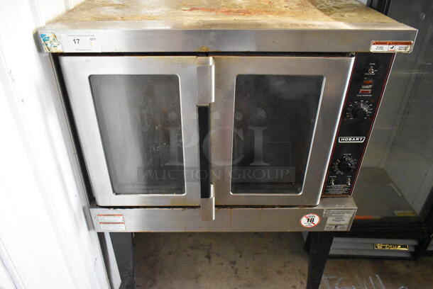 Hobart HGC5-11D3 Stainless Steel Commercial Natural Gas Powered Full Size Convection Oven w/ View Through Doors, Metal Oven Racks and Thermostatic Controls on Metal Legs.