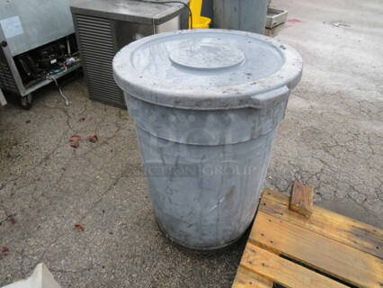 One Rubbermaid Brute Trash Can, With Lid  On A Dolly.