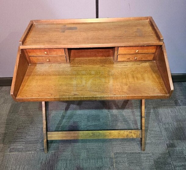 Antique wooden secretary style desk. Is two separate pieces. Bottom half folds out with a metal chain and the top part sits on. Nothing broken, in good condition. Could be cleaned up nicely to make a beautiful antique addition to any space! 36"H x 38"W x 27"D. 
 - Image 3 of 3