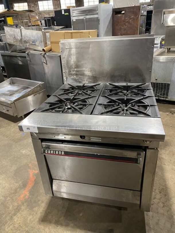 Garland Commercial Natural Gas Powered WIDE BODY 4 Burner Stove! With Oven Underneath! All Stainless Steel! With Raised Back Splash! GREAT FOR BIG POTS! On Legs! - Image 1 of 10