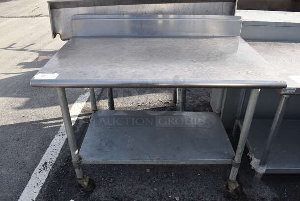 Stainless Steel Table w/ Back Splash and Metal Under Shelf on Commercial Casters. 48x30x41.5