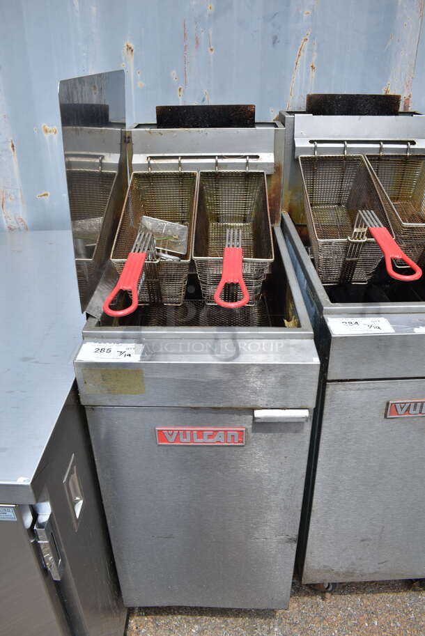 Vulcan LG300-1 Stainless Steel Commercial Floor Style Natural Gas Powered Deep Fat Fryer w/ Side Splash Guard and 2 Metal Fry Baskets on Commercial Casters. 90,000 BTU. - Image 1 of 5