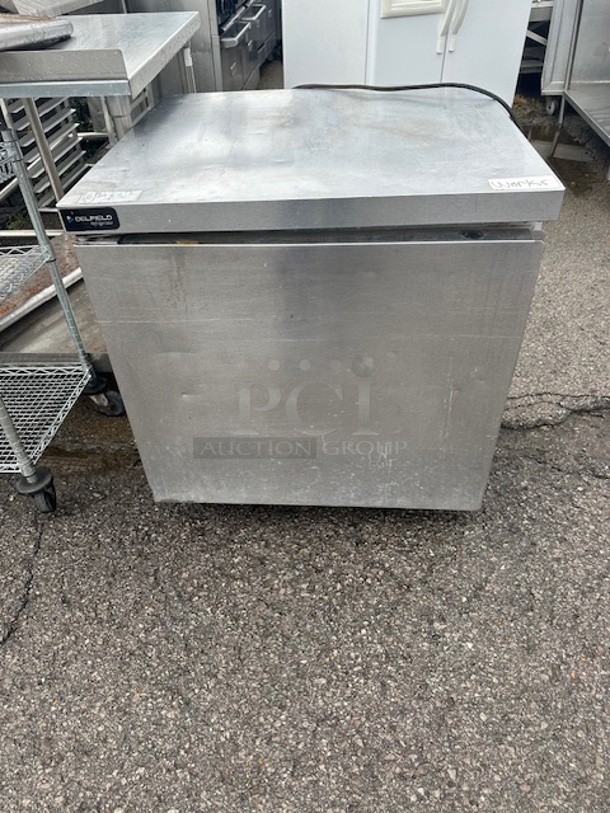 One WORKING Delfield SS 1 Door Under Counter Refrigerator With 2 Racks On Casters. Model# GUR32P-S-10. 115 Volt. 32X32X33.5 - Image 1 of 2